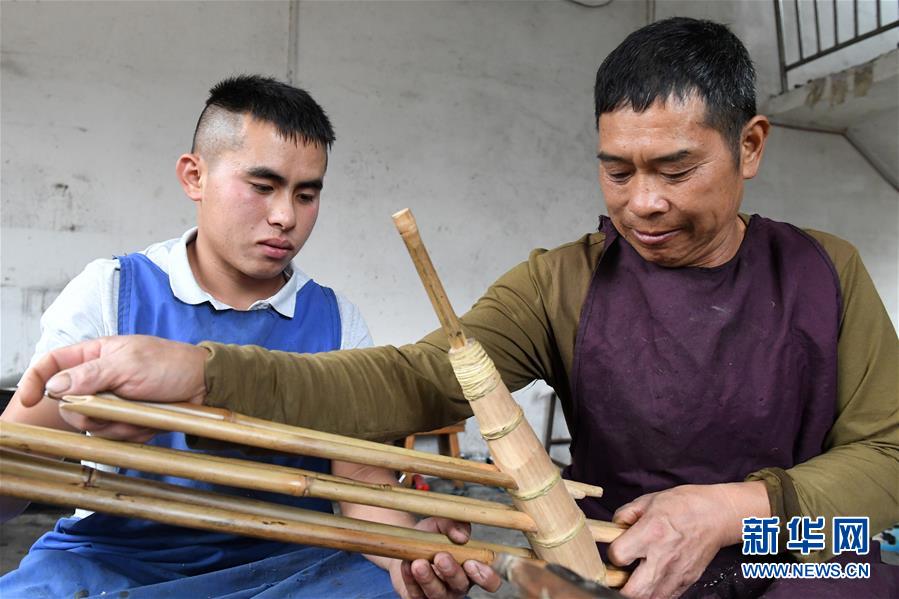 杜信文（左）和父親杜慶仁一起製作蘆笙。