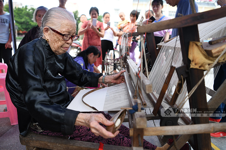 一位仫佬族藝人正在展示土布紡織技藝
