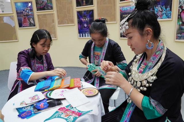 侗族「繡娘」在展示剪紙刺繡技藝。